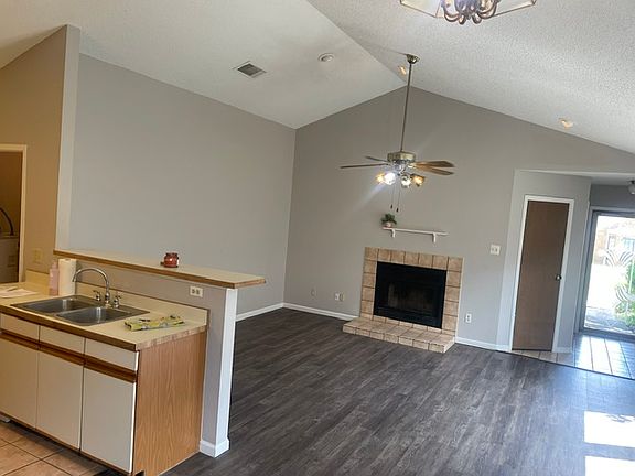 Living room with wood burning fireplace. Picture is taken from dining area.