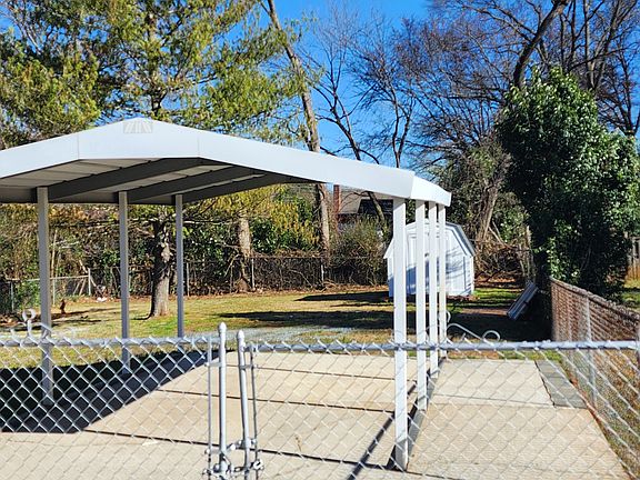 Concrete carport with large gated backyard and 5 x 10 shed.