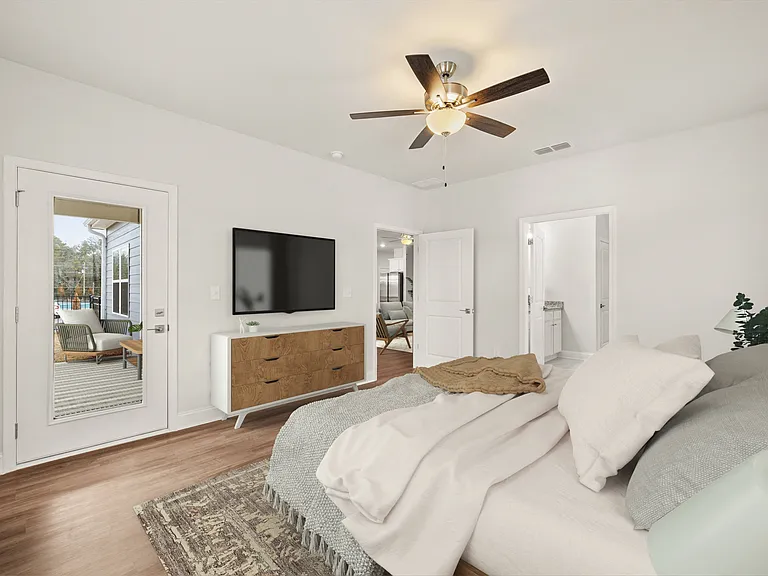 Primary suite featuring a contemporary ceiling fan, stylish entertainment area, and bright, sunlit windows.