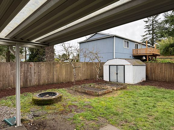 Three raised beds (two shown here) are located to maximize sun for growing veggies. A tool shed provides storage.