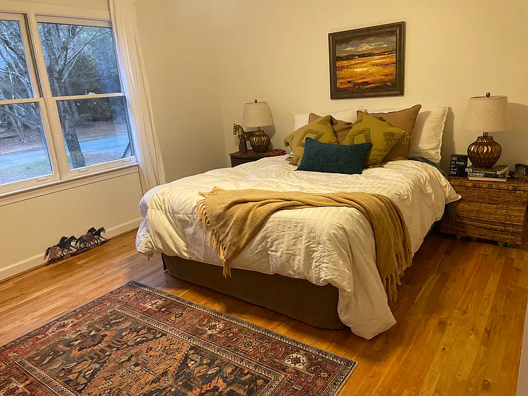 Large bedroom with comfy queen bed. Second story view with filtered afternoon light.
