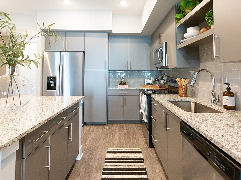 Stunning kitchens are complete with quartz countertops and subway tile backsplash.