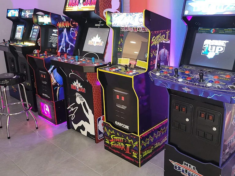 Dedicated recreation area with multiple arcade cabinets and open floor spaceideal for relaxing and socializing at home.