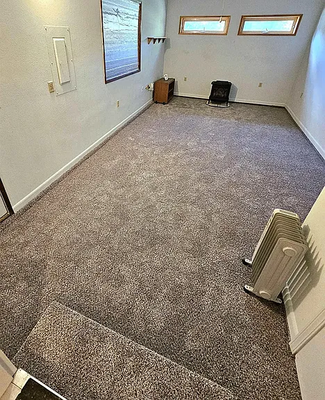 Extra room with gas furnace (converted garage) and door leading to the newer garage