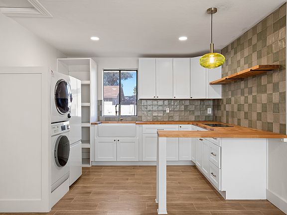 Brand new beautiful kitchen! Complete with butcher block countertops, farmhouse sink, new induction cooktop stove, stacked washer and dryer, new cabinets, and stylish backsplash!