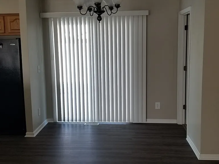 Sliding door to back yard with vertical blinds.