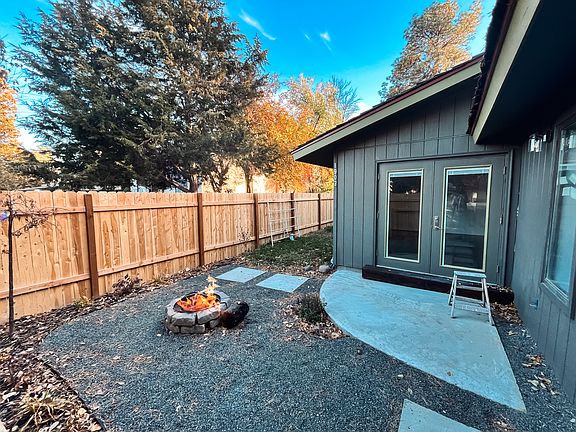 Fenced backyard with outswing french doors and fire pit