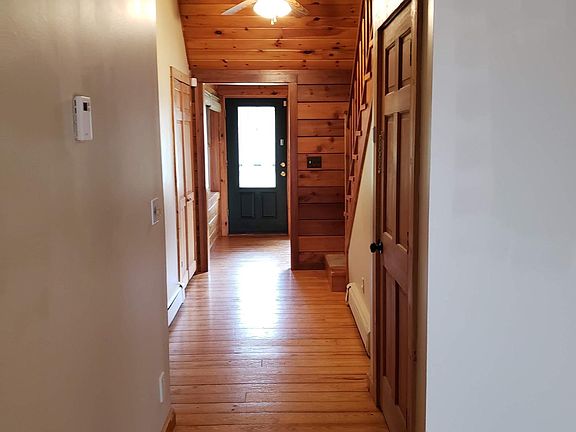 View of hall from living area to front door (laundry room door on the right).
