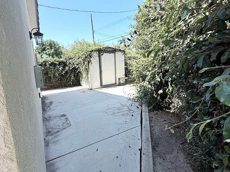 Concrete backyard with a shed