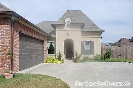 Living room has hardwood floors and large windows overlooking the covered patio