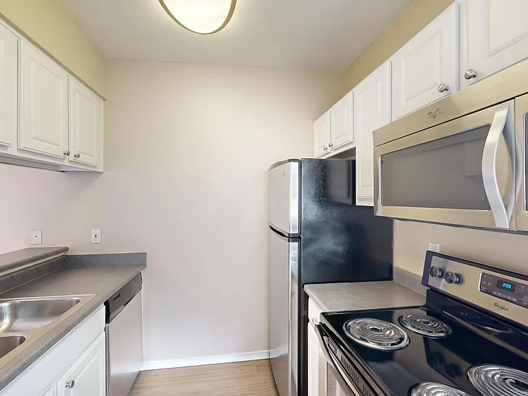 Apartment kitchen with wood-style flooring.