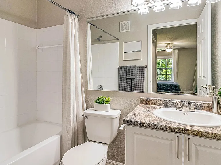 Experience bright bathrooms adorned with large mirrors and radiant vanity lighting.