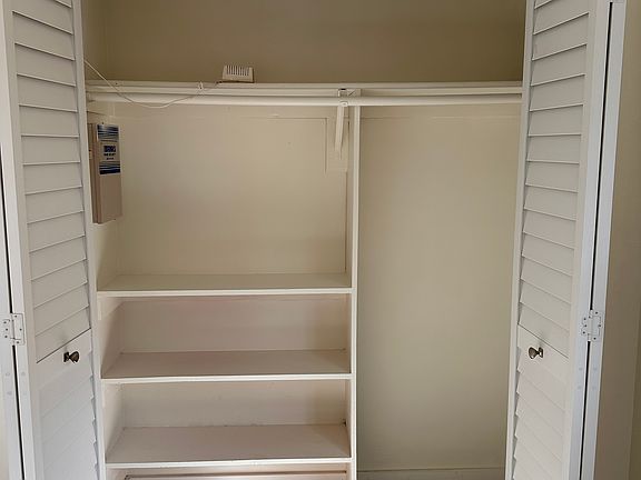 Second bedroom closet, new closet doors, new floors, new window treatments and impact windows.