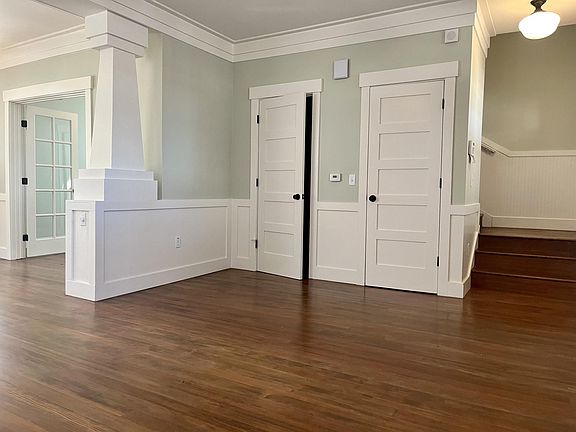 Slightly open door leads to half bath on first level. Note wood floors.