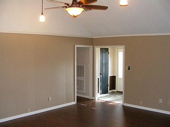 Additional view of LIving Area (14X20). This view is looking towards the front entrance with high ceilings, ceiling fans, interior paint & wide-plank wood laminate flooring.
