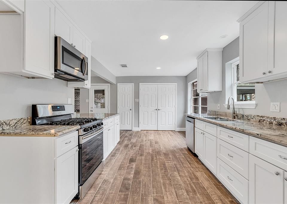 Kitchen is light and bright with beautiful white cabinets and granite counter tops.