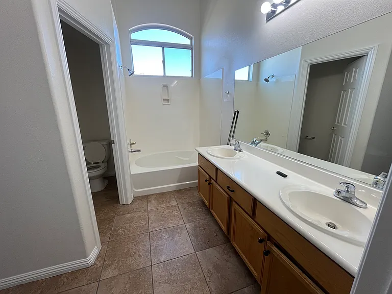 Primary Bedroom - Bathroom with private toilet room, tub, and dual sinks.