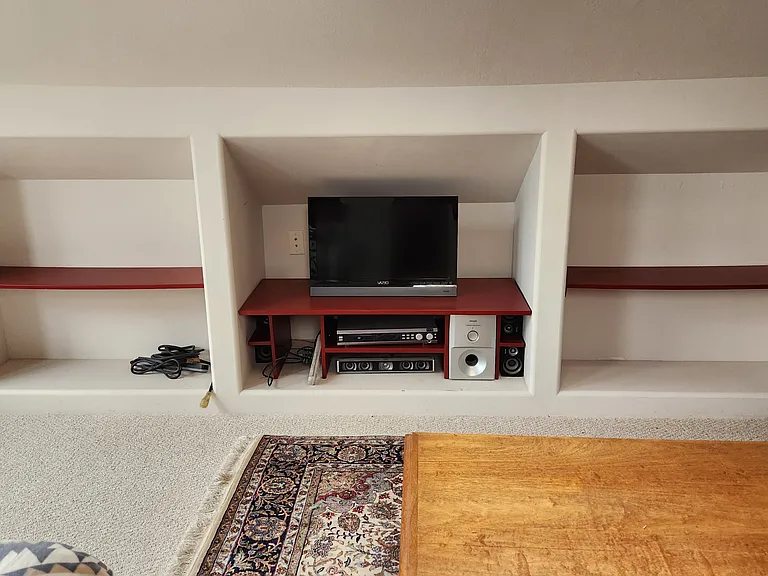 Loft bedroom storage and entertainment area from the foot of the bed.