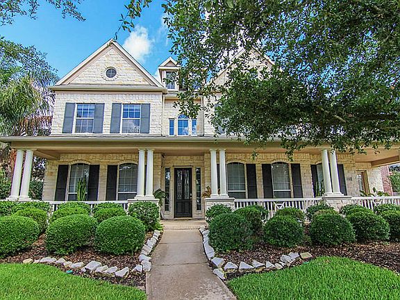 Beautiful landscaping and a covered front porch welcome your guests.
