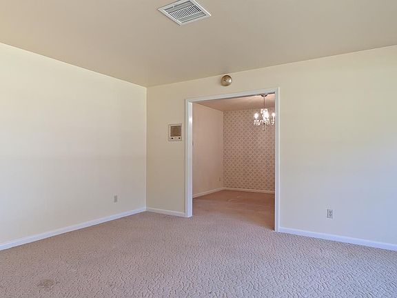 Spacious formal living off of the entry leads to the dining room.