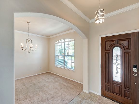 Entry foyer & dining room featuring archway and premium wood door