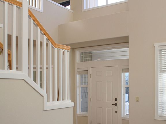 Soaring two story entry leads to spindle staircase. 
