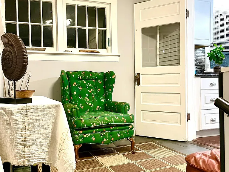 Sunroom leading to the outdoor space, and stairs down to the laundry and lower level apartment.