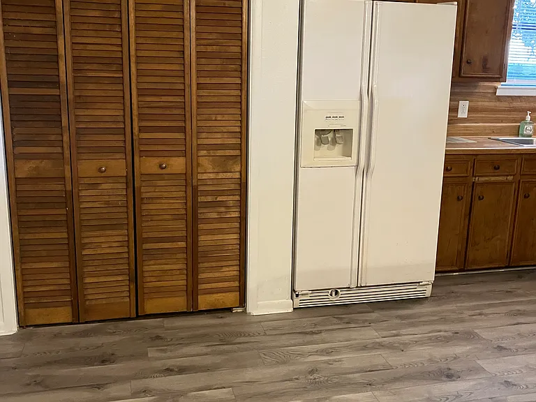 Pantry closet has washer/dryer connections and a newer water heater