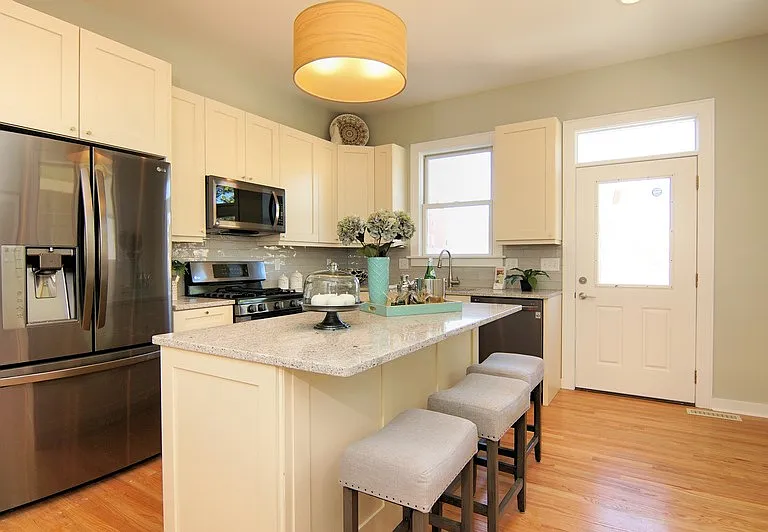 Kitchen with stainless steel appliances, quartz counters.