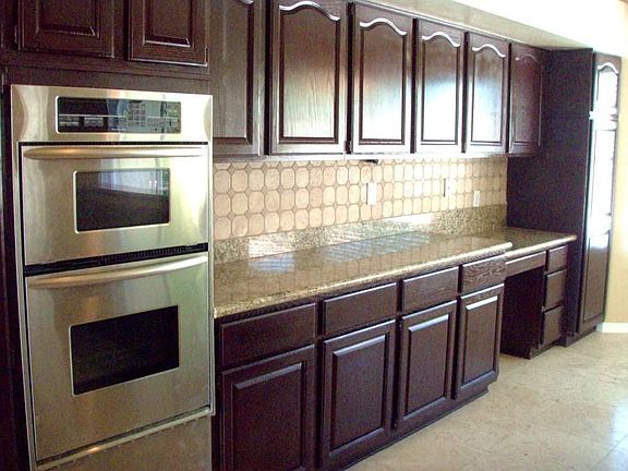 Dark Cabinets, Travertine Back Splash, and Kitchenaid Stainless Appliances