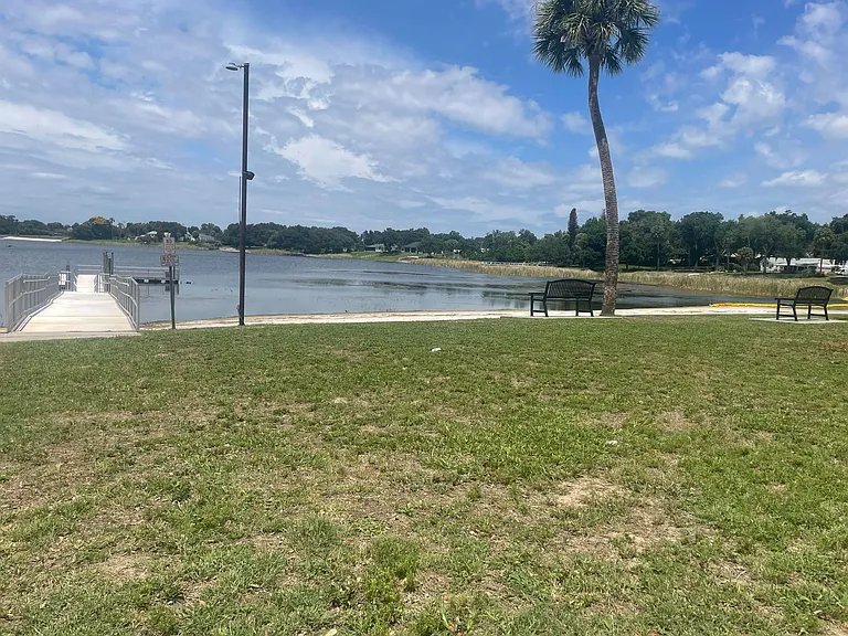 Waterfront outdoor area with a dock, walking path, and benches overlooking the lakeideal for relaxing and enjoying views.