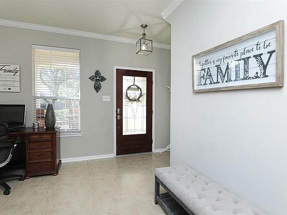 The beautiful front door makes a lovely entry with tile floors and crown moulding.