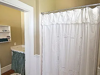 Up shower/toilet looking through door to sink area.