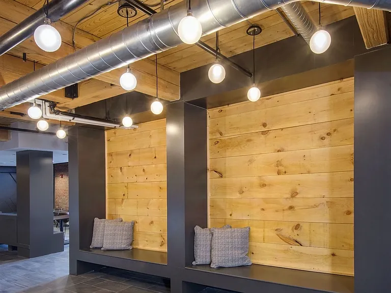 Hallway In Wall Wooden Seating With Gray Pillows.