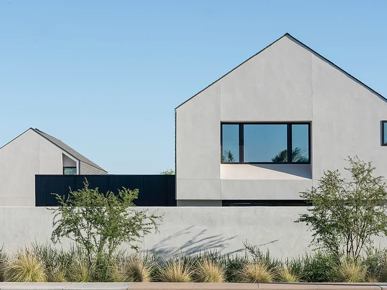 A quiet architectural composition of simple forms, desert landscaping, and privacy walls reinforces the home's sense of retreat.