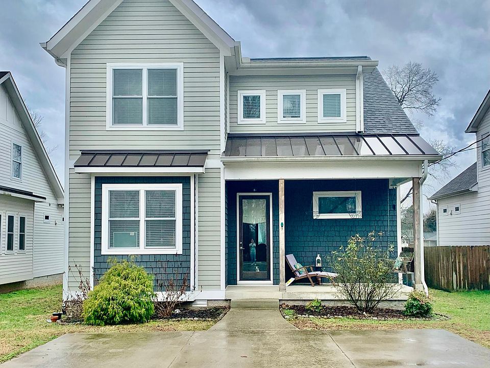 Front of home with large driveway.