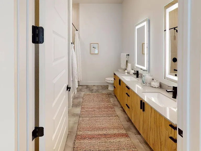 Enjoy luxe bathrooms with backlit bathroom mirrors, upgraded fixtures, and quartz countertops