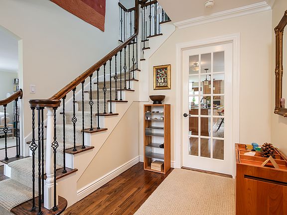 Entrance hall offering a striking staircase and providing broad views of the first floor.