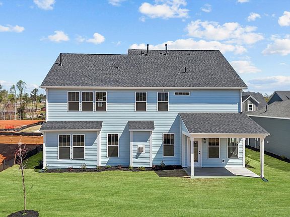 Light blue exterior two story home with rear covered porch at Wells Crossing by DRB Homes in Seneca,