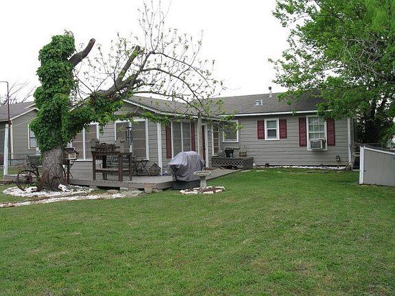 BACK OF HOUSE.  NOTICE BACK DOOR AND NICE WOOD DECK.