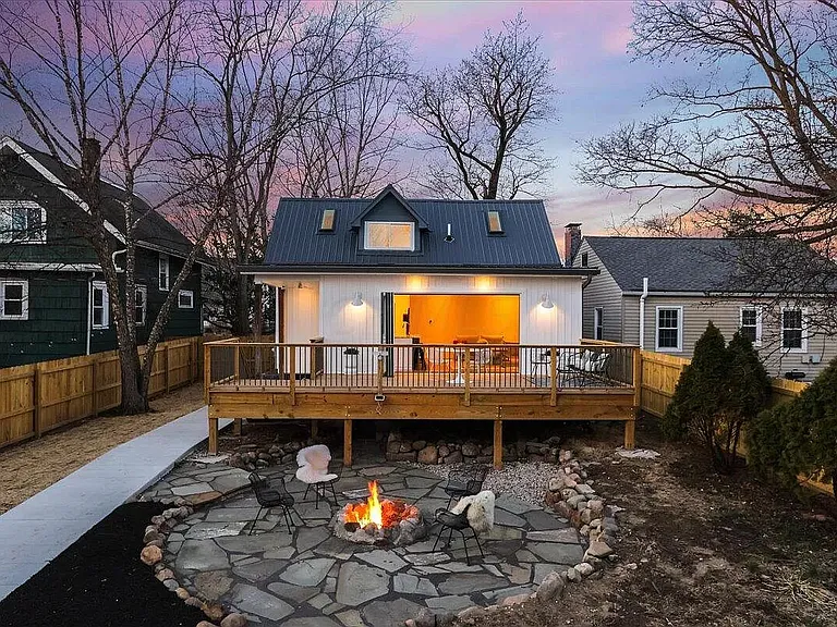 huge deck with lower stone patio and fire pit in back of house