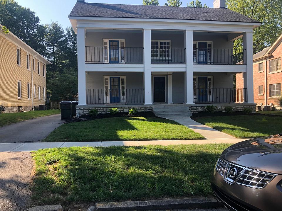 Gorgeous painted brick building with stately front porches. Blue hydrangeas and boxwoods provide the classic landscaping.