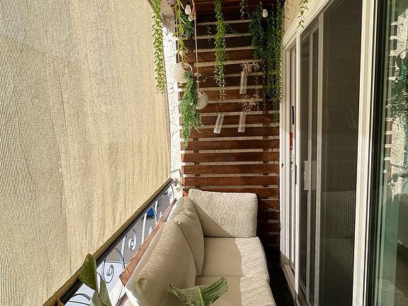 covered wooded balcony with a privacy shade