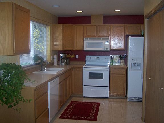 The kitchen features oak cabinets, pantry & a window overlooking the backyard.
