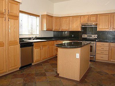 Open kitchen that features slab granite with stainless steel appliances