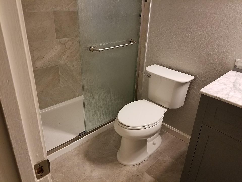 Bathroom: tile flooring and shower walls, marble counter top with edged tile work
