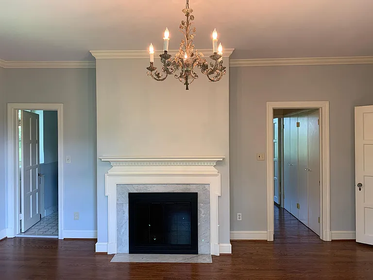 Primary bedroom. Bathroom with double, marble vanity to the left, hallway to sitting room on the right. Marble surround on the fireplace