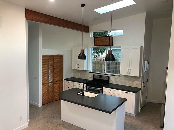 Open concept kitchen to living space. High ceilings with tons of natural light coming in from large custom windows and skylights.