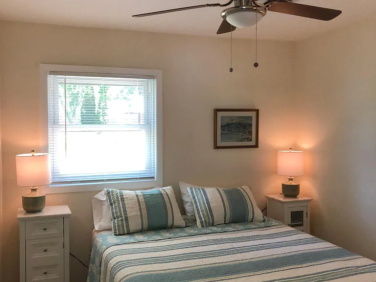 Bedroom #2 with Queen bed, dresser with mirror/hairdryer, ceiling fan, towel hooks, and closet.