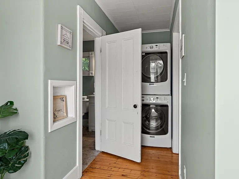 Enjoy the convenience of an in-unit laundry area featuring a stacked, full-sized washer and dryer. Tucked away neatly in a hallway, this amenity ensures you can pack light and keep your clothes fresh during your stay. The area maintains the home's charm w